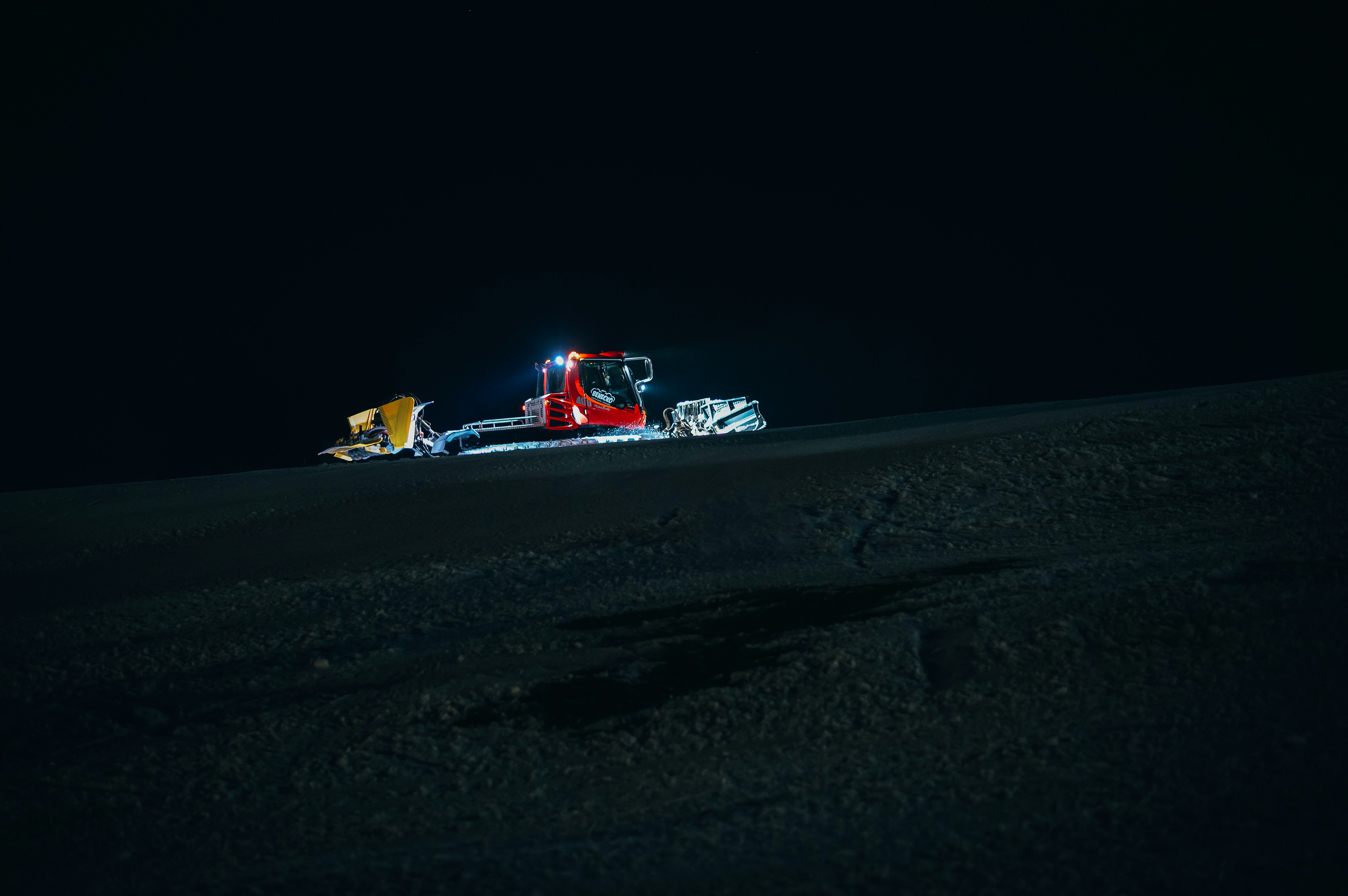 red and white formula 1 on snow covered ground during night time